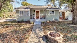 A single-story house with a front porch, a small front yard, and a pathway leading to the door. - Missouri Escape w/ Furnished Patio, Near Downtown! (Nevada)