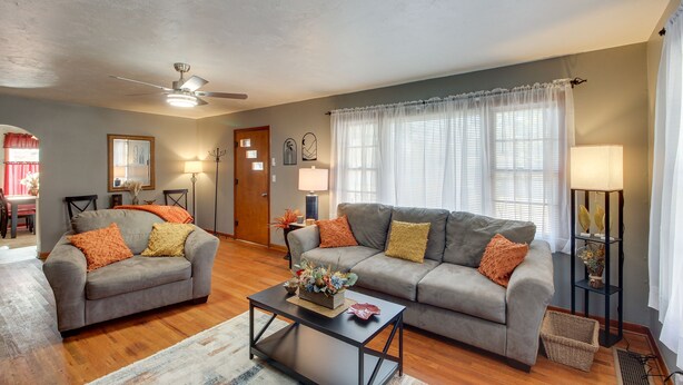 A living room with two grey sofas, a coffee table, a ceiling fan, and a floor lamp. - Missouri Escape w/ Furnished Patio, Near Downtown! (Nevada)