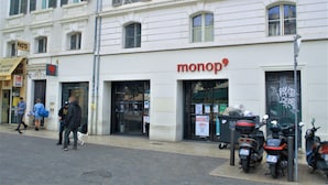 Un edificio con escaparate que dice 'monop'.