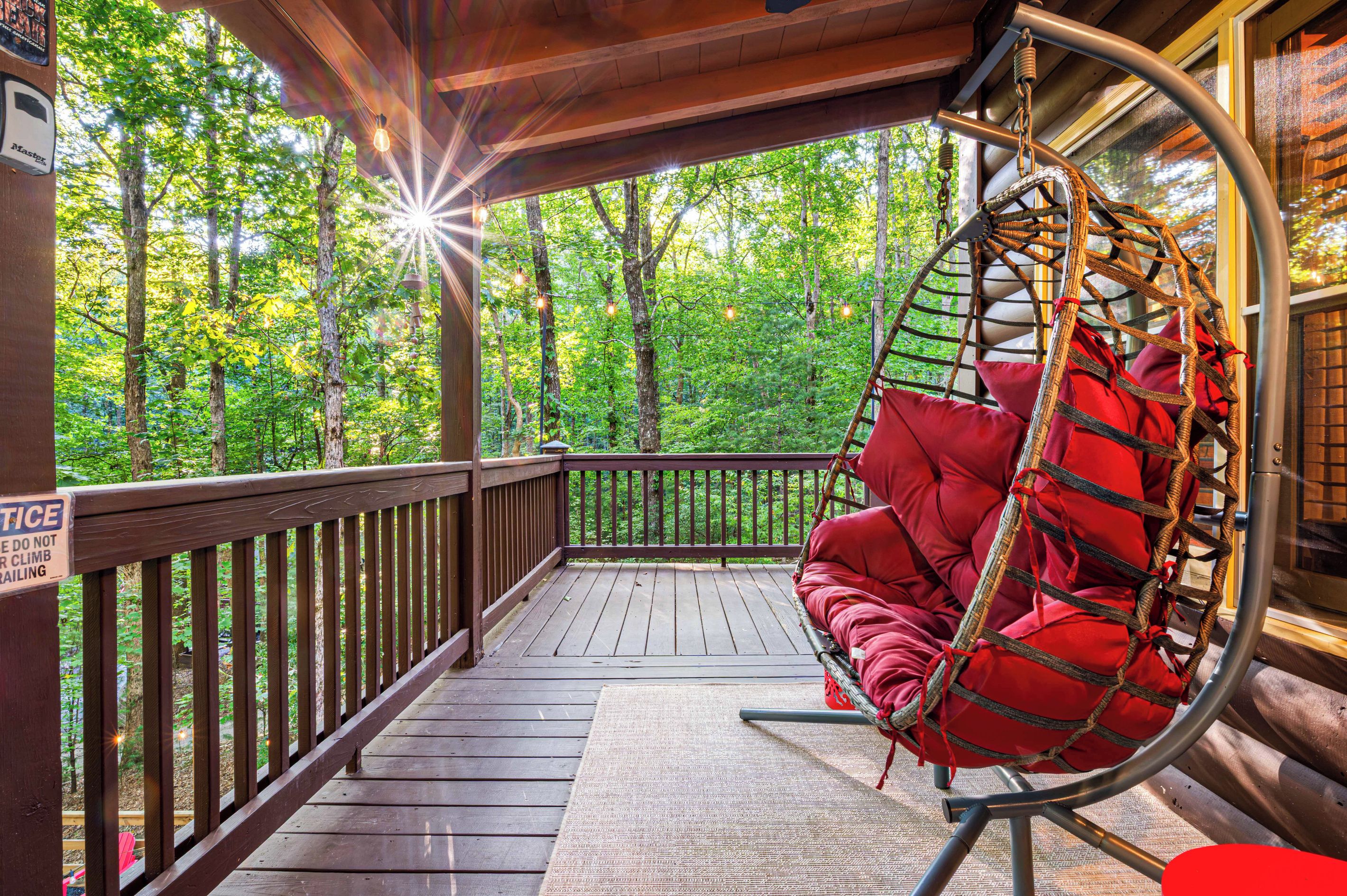 A wooden deck with a hanging chair and a sign warning against climbing.