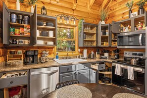 Una cocina moderna con microondas integrado, horno y barra para café.