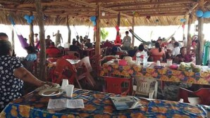 A crowded outdoor dining area with thatched roof and colorful tablecloths. - Barra Zacapulco - Palapa Abrabam (Acapetahua)