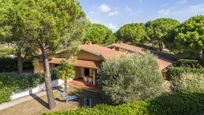 A villa with a patio, surrounded by trees and greenery. - Argentario Giannella Apartment (Orbetello)