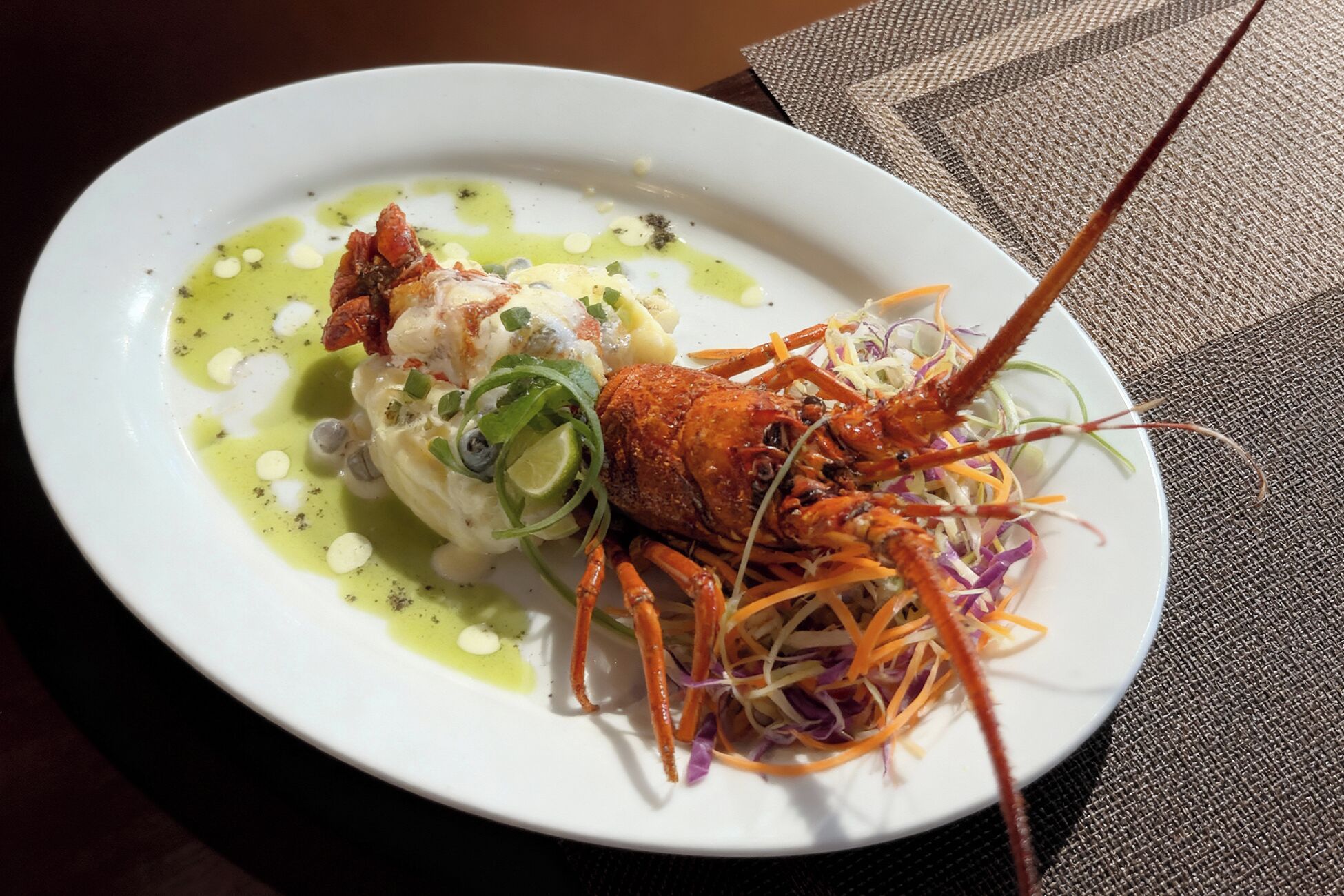 A plate of lobster with a side salad and a sauce.