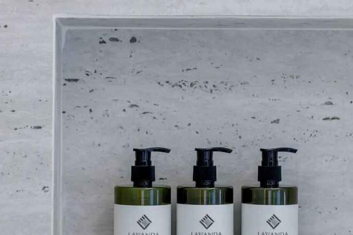 Three bottles of LAVANDA body wash on a textured surface.