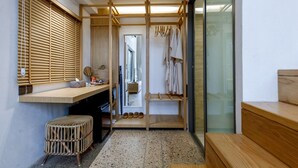 A modern bathroom with a wooden vanity, a mirror, and a towel rack.