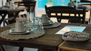A wooden table with a crocheted placemat, a white pitcher, and a glass pitcher. - Pousada VIGLAMO JERI (Jijoca de Jericoacoara)