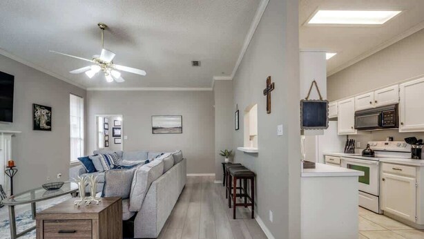 A modern kitchen with white cabinets, a microwave, and a coffee maker. - Spacious Brick House 3BR 2BA A+ (Denton)