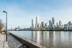 A waterfront cityscape with modern high-rise buildings. - 5 Odessa St (London)