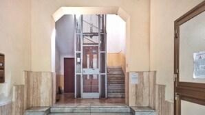 A staircase leading to a metal gate, with a door on the right and a wall with a sign on the left. - Annacati House apartment, from 1 to 6 people, 3 bedrooms 2 bathrooms 1 terrace (Palermo)