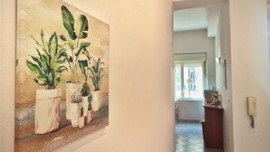 A hallway with a large painting of potted plants on the wall. - Annacati House apartment, from 1 to 6 people, 3 bedrooms 2 bathrooms 1 terrace (Palermo)