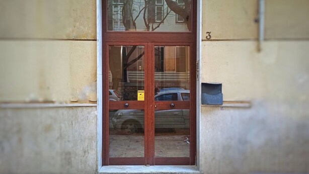 A wooden door with a glass panel, a yellow sign, and a mailbox on the wall. - Annacati House apartment, from 1 to 6 people, 3 bedrooms 2 bathrooms 1 terrace (Palermo)
