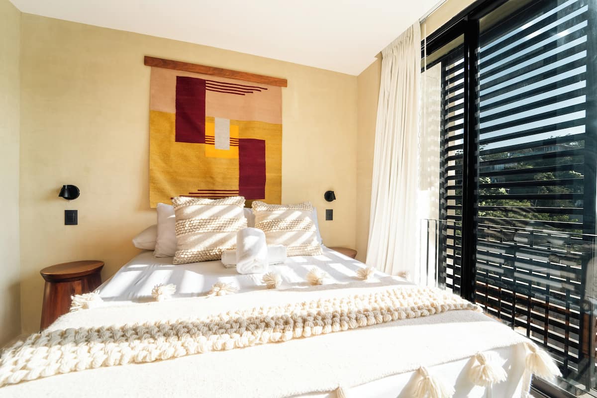 Un lit bien fait, avec du linge de lit blanc et une tête de lit décorative.