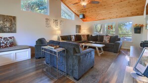 A spacious living room with a high ceiling, wooden beams, and large windows. - Sierra National Forest & Yosemite Estate + Orchard Retreat (Oakhurst)