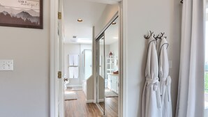A hallway with wooden flooring, white walls, and a sliding glass door leading to a bathroom. - Sierra National Forest & Yosemite Estate + Orchard Retreat (Oakhurst)