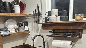Een keuken met een houten aanrecht, een zwarte spoelbak en een ingebouwde kookplaat.