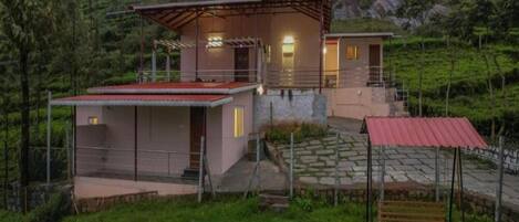 Una casa moderna con un patio amplio, una piscina pequeña y un banco de madera.