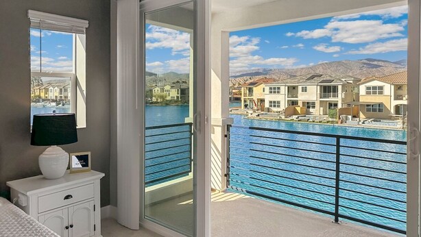 A bedroom with a sliding glass door leading to a balcony with a pool view. - Casa Marina -15 min to Coachella (Indio)