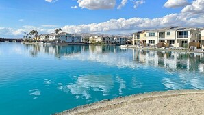 A waterfront property with multiple buildings, a clear blue sky, and calm water reflecting the structures. - Casa Marina -15 min to Coachella (Indio)