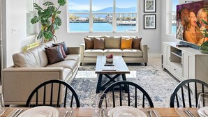 Un salon moderne avec un canapé, une table basse et un coin repas.