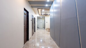 A hallway with a marble floor, a ceiling fan, and recessed lighting. - Treebo City Center (Nagpur)