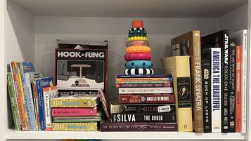 A bookshelf with various books, toys, and games.