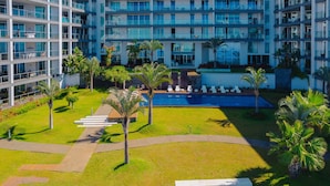 A modern hotel with multiple floors, a central pool area, and surrounding greenery. - FLH Seaside Luxury at Madeira Palace Residence (Funchal)