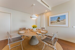 Uma área de refeições com uma mesa redonda, cadeiras e um lustre.