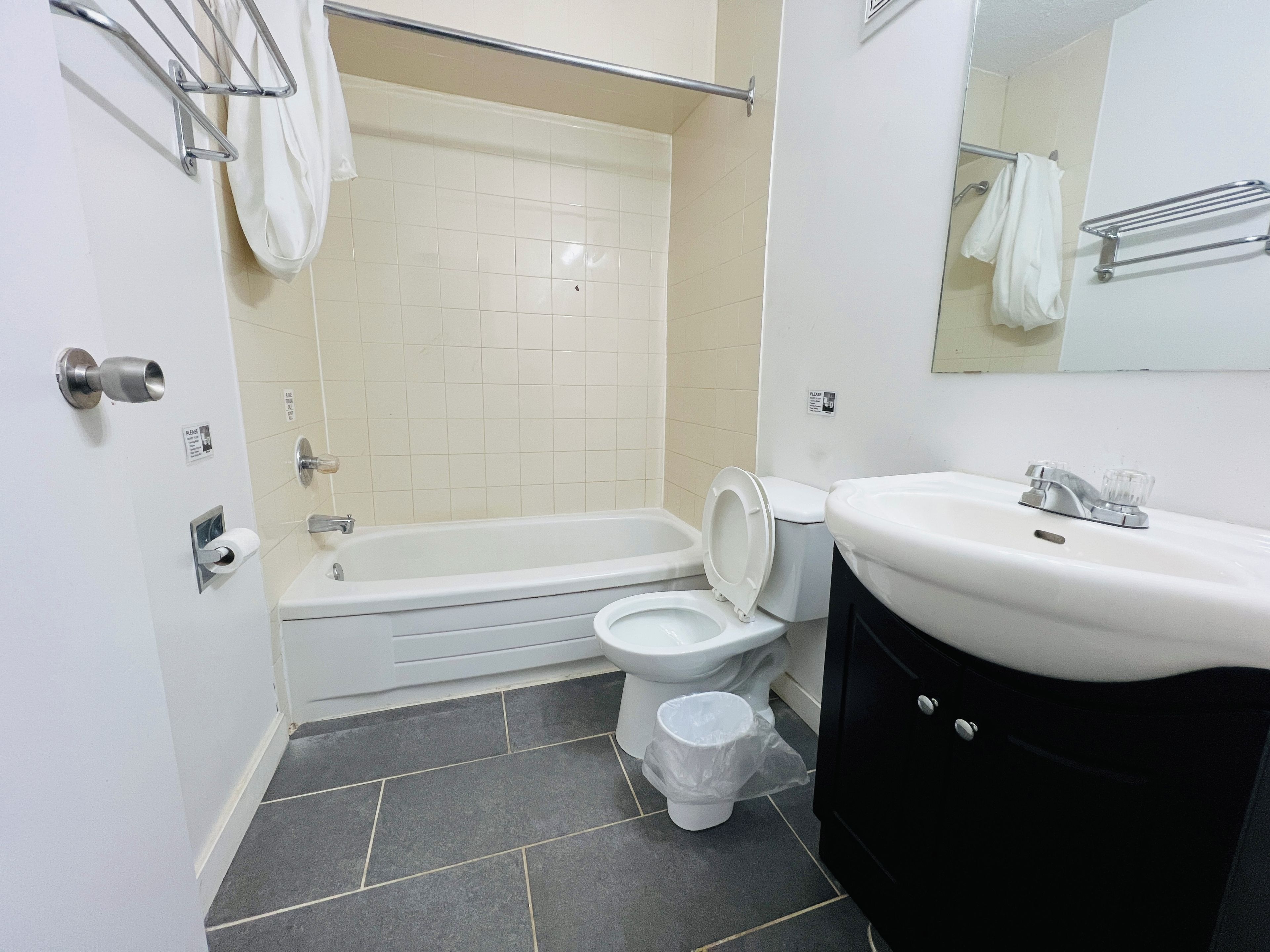 A bathroom with a bathtub, toilet, and sink.