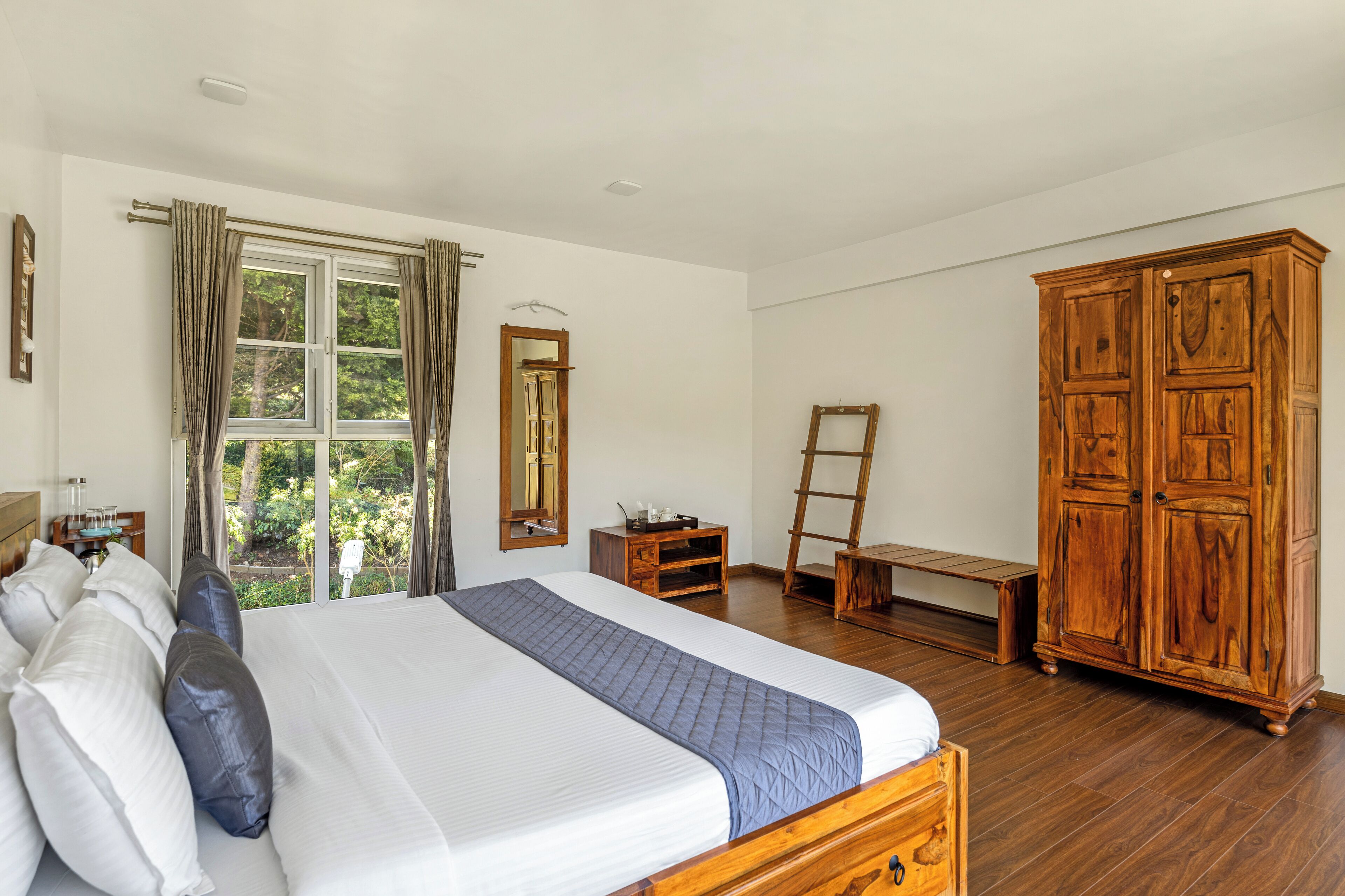 Une chambre à coucher avec un grand lit, une armoire en bois et un bureau avec une chaise.