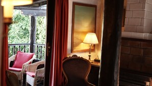Una habitación con sillones de mimbre, chimenea y lámpara.