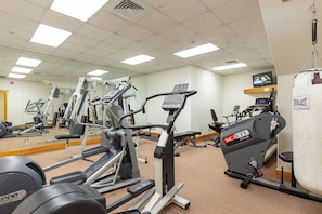 Ett gym med olika typer av träningsutrustning, inklusive löpband och styrketräningsmaskiner.