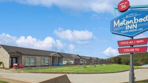 Un motel que muestra un cartel con servicios como aire acondicionado frío, WiFi y televisión en color.