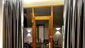 A hotel room with a bed, a sliding glass door to a balcony, and curtains. - Vilu Residence (Maamigili)