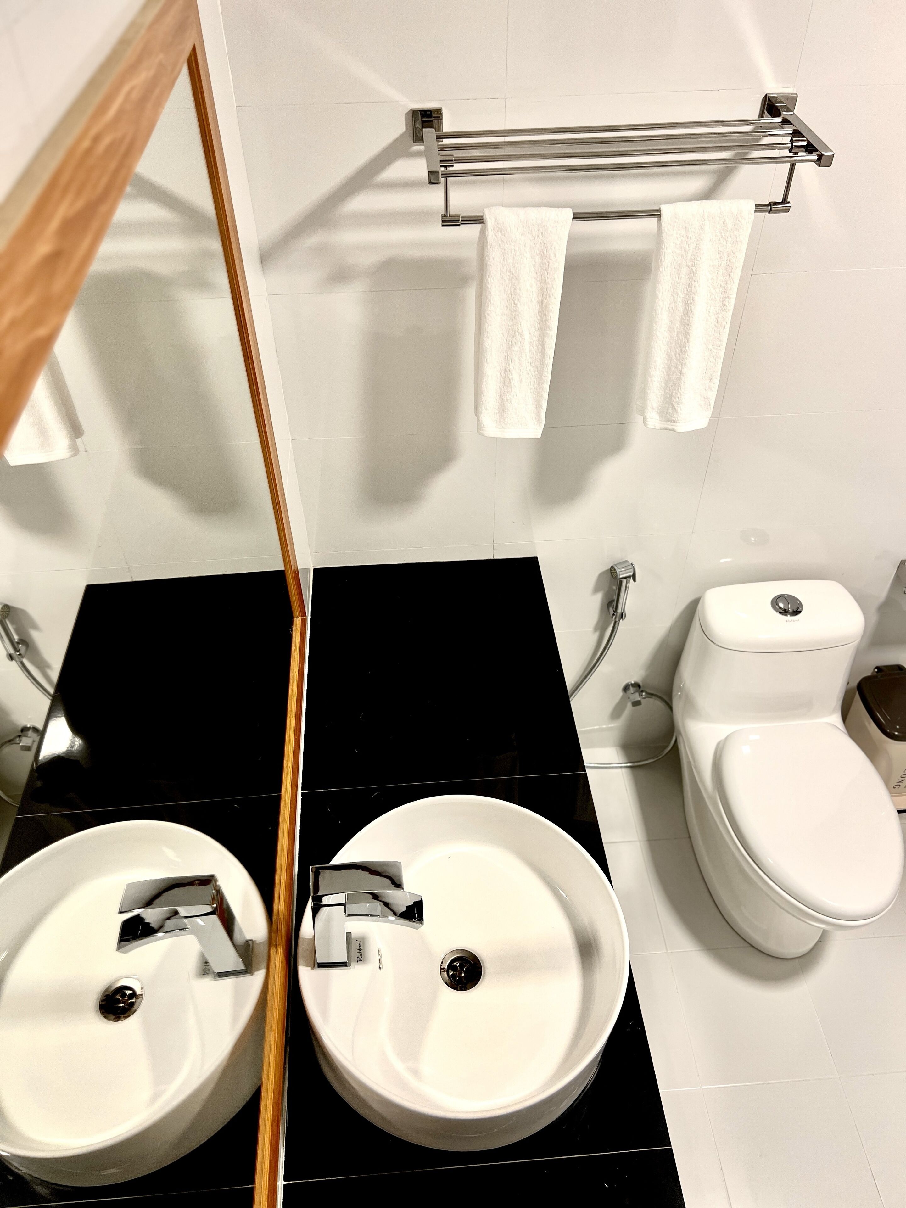 Ein Badezimmer mit zwei Waschbecken, einer Toilette und einem Handtuchhalter.