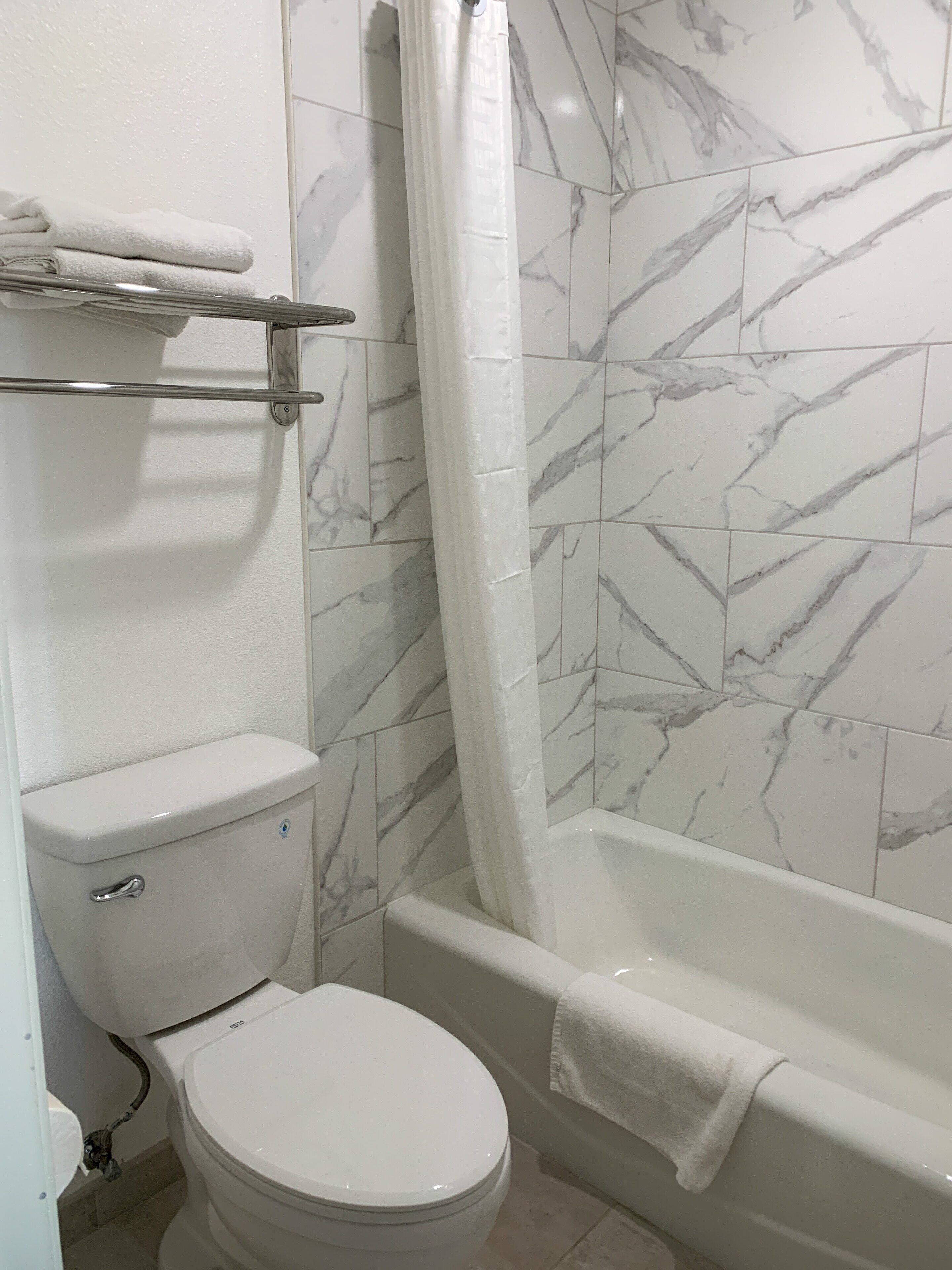 Ein Badezimmer mit Toilette, Badewanne und Duschvorhang.