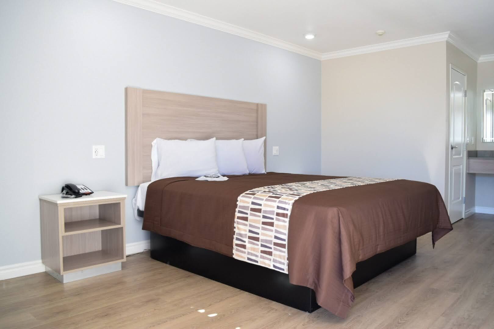 A bedroom with a bed, a bedside table, and a nightstand.