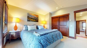 Cozy retreat with a large bed, wooden wardrobe, and a nightstand with a lamp.