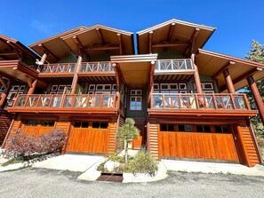 Stunning log cabin-style building with a central entrance and two upper-floor balconies.