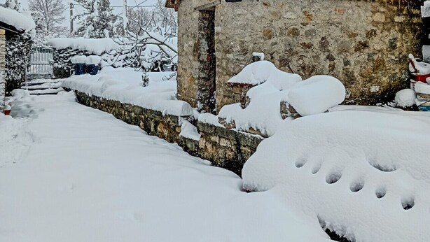 A stone building with a snow-covered roof and walls, surrounded by snow-covered ground and trees. - #914 Home in Irpinia (Nusco)