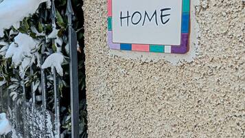 Un cartel de número de casa con la inscripción '#914 HOME' sobre una pared con textura.