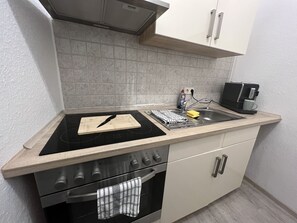 Een koelkast, een oven, een kookplaat, een koffiezetapparaat/waterkoker