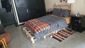 Une chambre à coucher avec un lit, une armoire, une table de chevet et une lampe.