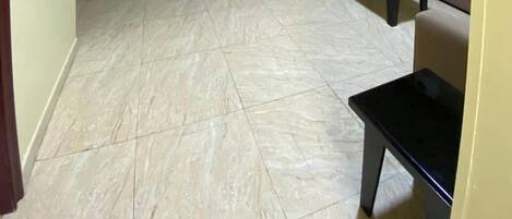Un amplio salón con un conjunto de sofás, una mesa de centro y un mueble para televisión contra la pared.