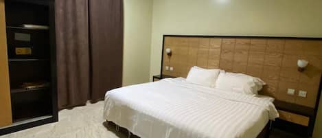Un dormitorio con cama, armario y luz de techo.