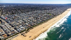 Vista aérea de una ciudad costera con una zona residencial densamente poblada y una extensa playa.