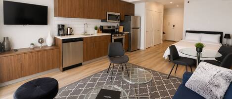 A modern apartment with a kitchen, dining area, and living room.