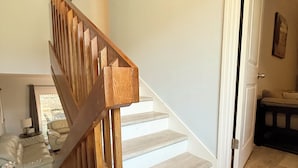 Eine Treppe mit Holzwangen, die zu einer Empore führt.
