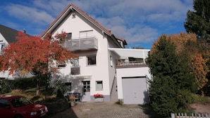 Une maison à deux étages avec un balcon, un garage et une allée.