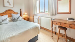 A bedroom with a bed, bedside lamp, wooden dresser, and a window with curtains. - Lake View 2 - UK45578 (Louth)
